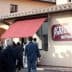 People walking towards the entrance of Agrilosteria del Frantoio with a red awning. - Olive Oil Times
