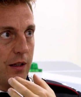 A man in a formal uniform with a decorative collar engaged in conversation with another individual. - Olive Oil Times