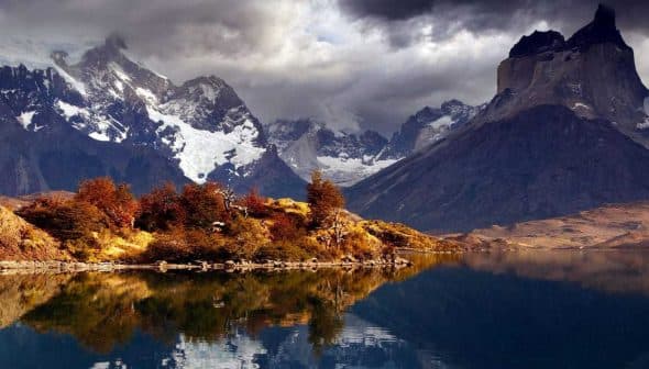 Mountain landscape featuring peaks and a lake reflecting the scenery in Torres del Paine National Park. - Olive Oil Times
