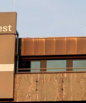 Signage of Stiftung Warentest displayed on a building exterior with a large plus symbol. - Olive Oil Times