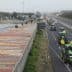 Multiple tractors driving on a highway with vehicles in the background. - Olive Oil Times