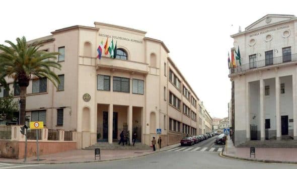 Two educational buildings in Jaén, featuring flags and distinct architectural styles. - Olive Oil Times