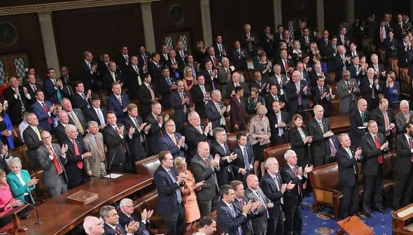 Members of the U.S. Congress standing and applauding during a session in the House chamber. - Olive Oil Times