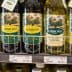 A selection of olive oil bottles displayed on a store shelf, featuring different brands and types. - Olive Oil Times