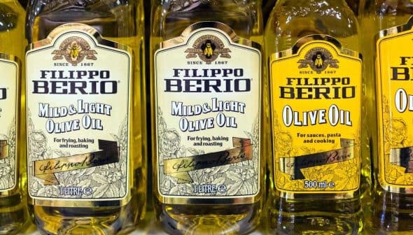 Five bottles of Filippo Berio olive oil in various types, including mild and light options. - Olive Oil Times