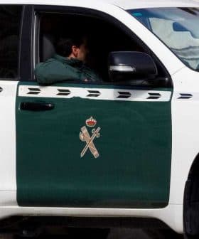 A Guardia Civil vehicle parked with a visible officer inside, featuring a green and white color scheme. - Olive Oil Times