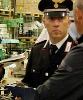 Two Italian Carabinieri officers inspecting a facility with documents and equipment. - Olive Oil Times