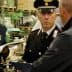 Two Italian Carabinieri officers inspecting a facility with documents and equipment. - Olive Oil Times