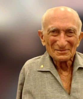 Elderly man with a bald head and gray shirt, smiling at the camera. - Olive Oil Times