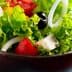 Bowl of fresh garden salad containing lettuce, tomatoes, olives, and onions. - Olive Oil Times