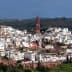 Panoramic view of Montoro, a village with white buildings and a prominent clock tower in the background. - Olive Oil Times