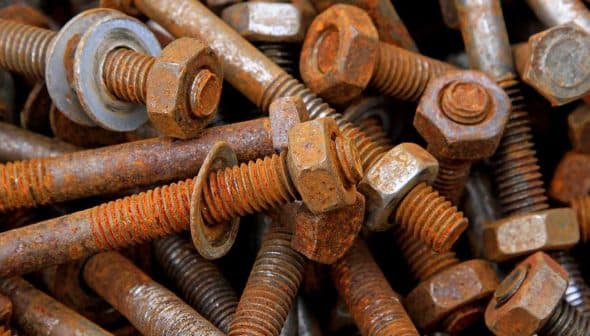 A collection of rusty bolts and nuts piled together in a disorganized manner. - Olive Oil Times