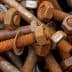 A collection of rusty bolts and nuts piled together in a disorganized manner. - Olive Oil Times
