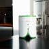 Compact white and green kitchen appliance with a button on top, placed on a dark countertop. - Olive Oil Times