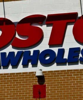 Sign displaying the Costco Wholesale logo on a brick wall. - Olive Oil Times