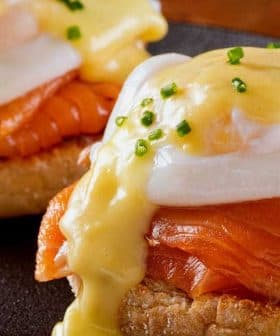 Two servings of Eggs Benedict featuring poached eggs, smoked salmon, and hollandaise sauce on English muffins. - Olive Oil Times