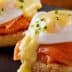 Two servings of Eggs Benedict featuring poached eggs, smoked salmon, and hollandaise sauce on English muffins. - Olive Oil Times