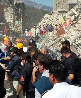 Emergency responders and volunteers assisting at a collapsed building site after an earthquake. - Olive Oil Times