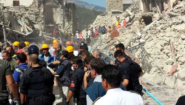 Emergency responders and volunteers assisting at a collapsed building site after an earthquake. - Olive Oil Times