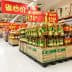 Rows of cooking oil bottles arranged on pallets in a supermarket aisle. - Olive Oil Times