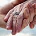 Close-up of two hands holding each other, one adorned with a silver ring. - Olive Oil Times