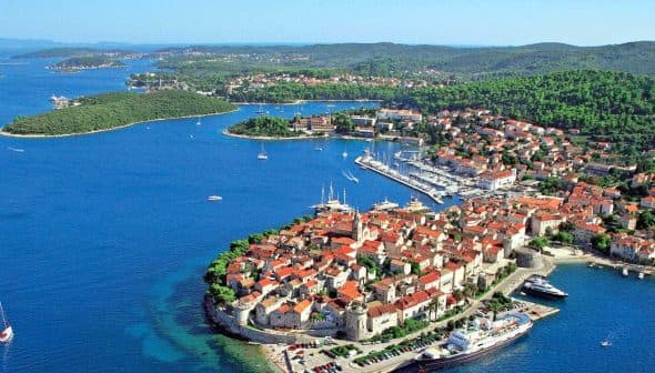 Aerial view of Korčula Island featuring the town and surrounding sea with boats. - Olive Oil Times