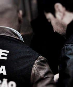 Two ASAE police officers in uniform with visible text on the back of their jackets. - Olive Oil Times