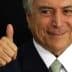 A man with gray hair and a suit giving a thumbs up gesture with a smile. - Olive Oil Times