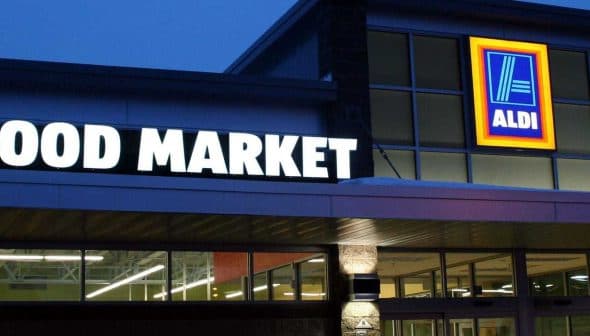 Exterior view of an ALDI food market with illuminated signage at dusk. - Olive Oil Times