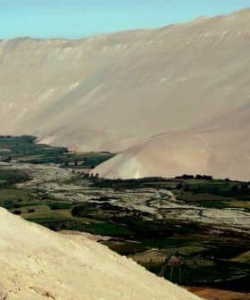 Aerial view of a valley surrounded by mountains with a river flowing through it. - Olive Oil Times