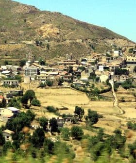 Panoramic view of a mountain village in the Kabylia region, featuring houses and agricultural land. - Olive Oil Times