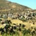 Panoramic view of a mountain village in the Kabylia region, featuring houses and agricultural land. - Olive Oil Times