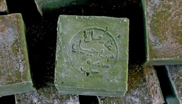 A close-up of a traditional Aleppo soap bar with an embossed design on its surface. - Olive Oil Times