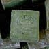 A close-up of a traditional Aleppo soap bar with an embossed design on its surface. - Olive Oil Times