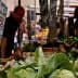Close-up of fresh green vegetables displayed at a market stall with price tags visible. - Olive Oil Times