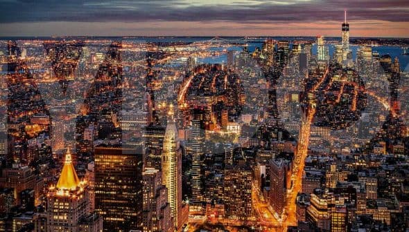 Aerial view of New York City skyline at night with illuminated buildings and streets. - Olive Oil Times