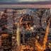 Aerial view of New York City skyline at night with illuminated buildings and streets. - Olive Oil Times