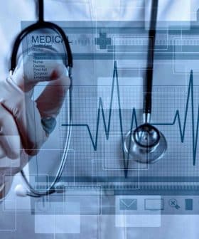 Medical professional wearing a white coat and stethoscope interacting with a digital health interface. - Olive Oil Times