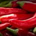 A close-up view of fresh red chili peppers stacked together. - Olive Oil Times