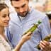 A couple inspecting olive oil bottles while shopping in a supermarket aisle. - Olive Oil Times