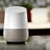 Google Home smart speaker with a white top and gray fabric base on a kitchen countertop. - Olive Oil Times