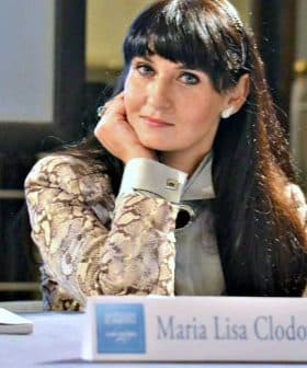 Maria Lisa Clodoveo seated at a table with her nameplate in front of her during an event. - Olive Oil Times