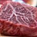 A close-up view of a raw beef cut showcasing marbling in the meat. - Olive Oil Times