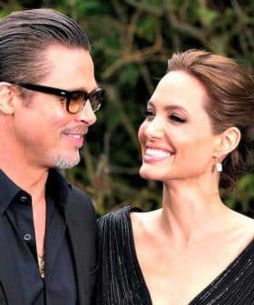 A couple smiling at each other while attending an event, both dressed in formal attire. - Olive Oil Times