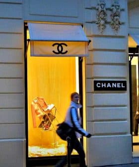 Chanel storefront featuring display windows with mannequins and branding. - Olive Oil Times