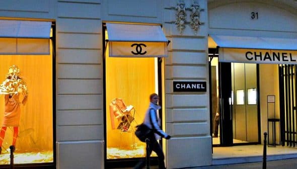 Chanel storefront featuring display windows with mannequins and branding. - Olive Oil Times
