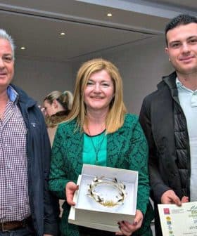 Three individuals posing with awards and a certificate at an event. - Olive Oil Times