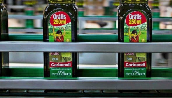 Bottles of Carbonell extra virgin olive oil labeled 250ml on a production line. - Olive Oil Times