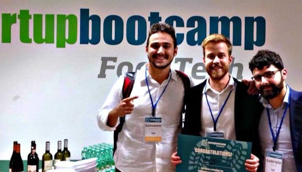 Three individuals posing together at a Startup Bootcamp Food Tech event with a sign in the background. - Olive Oil Times