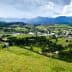 Aerial view of a rural area featuring green fields, a small town, and mountains in the background. - Olive Oil Times